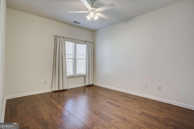 empty room with dark wood-type flooring and ceiling fan