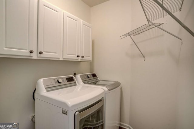 washroom featuring cabinets and washing machine and clothes dryer