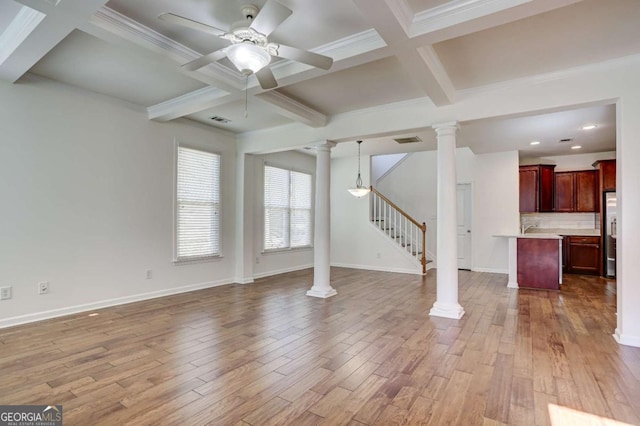 unfurnished living room featuring hardwood / wood-style flooring, ceiling fan, beam ceiling, coffered ceiling, and ornate columns