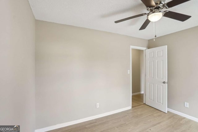 empty room with ceiling fan, a textured ceiling, and light wood-type flooring