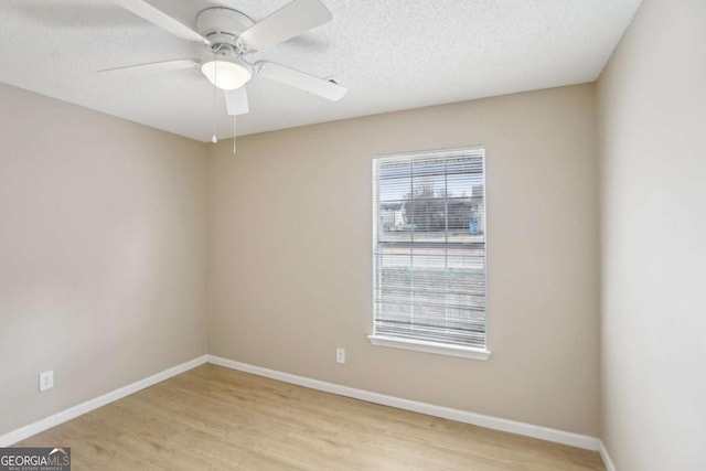 empty room with ceiling fan, light hardwood / wood-style floors, and a textured ceiling