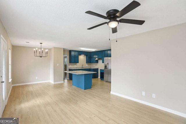 kitchen with light hardwood / wood-style flooring, a breakfast bar area, blue cabinetry, a kitchen island, and stainless steel fridge with ice dispenser