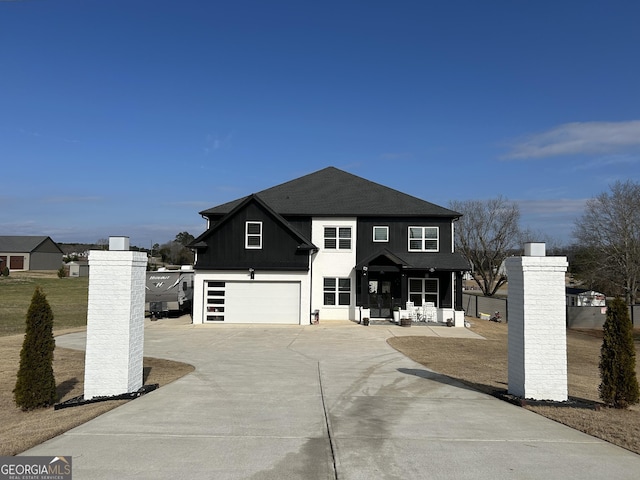 view of front facade featuring board and batten siding, roof with shingles, driveway, and an attached garage