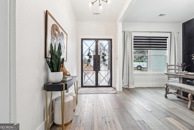 foyer entrance featuring visible vents, french doors, hardwood / wood-style flooring, and baseboards