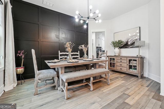 dining room featuring an inviting chandelier, visible vents, baseboards, and light wood-style floors