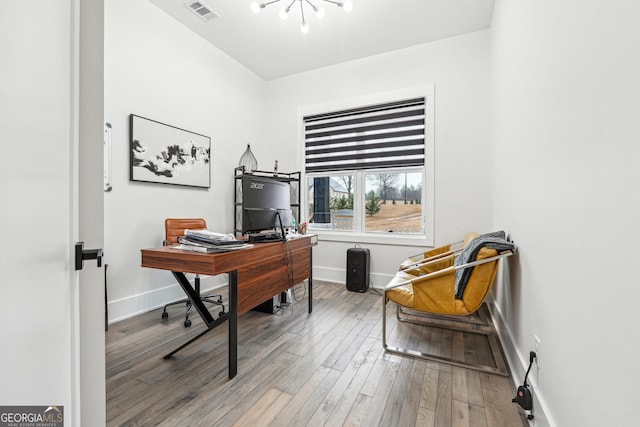 office area with wood finished floors, visible vents, and a chandelier
