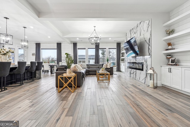 living area featuring a fireplace, recessed lighting, a chandelier, and light wood-type flooring