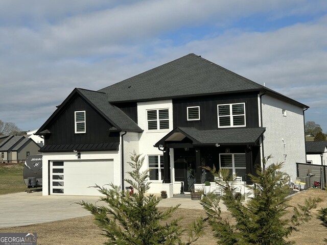 view of front facade featuring brick siding, driveway, an attached garage, and roof with shingles