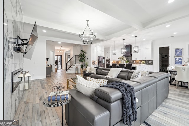 living area featuring a chandelier, recessed lighting, light wood-style flooring, and stairway