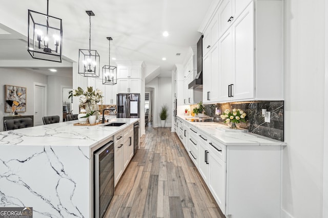 kitchen featuring white cabinets, a sink, beverage cooler, light wood-type flooring, and recessed lighting