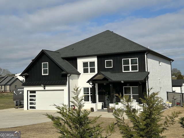 view of front of property featuring board and batten siding, a shingled roof, concrete driveway, and an attached garage
