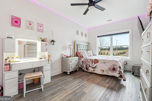 bedroom with baseboards, visible vents, ceiling fan, and wood-type flooring