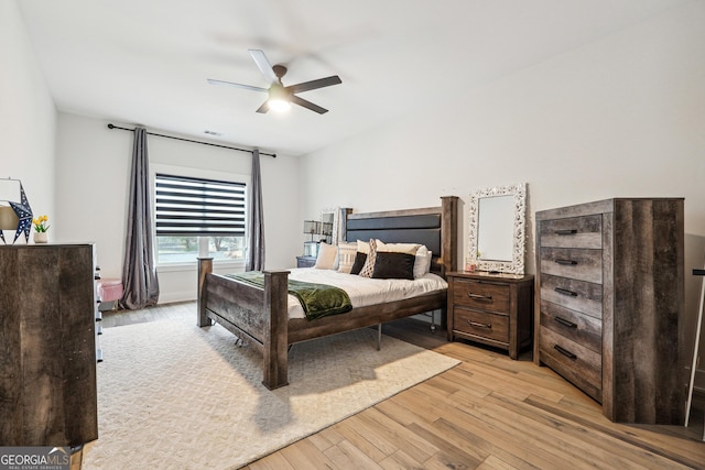 bedroom with light wood-style floors, ceiling fan, and visible vents