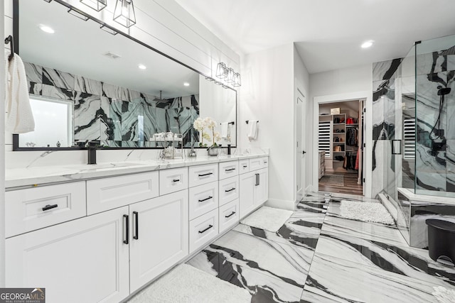 bathroom featuring recessed lighting, double vanity, a sink, a spacious closet, and a stall shower