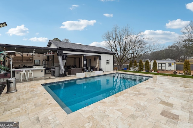 view of pool with a patio, an outdoor hangout area, an outdoor structure, and outdoor dry bar