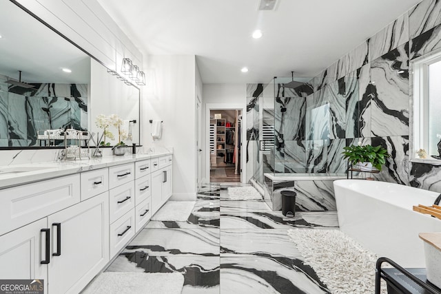 full bath featuring double vanity, recessed lighting, marble finish floor, and a marble finish shower