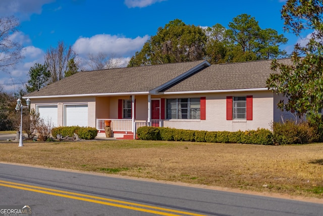 ranch-style home with a garage, a front lawn, and covered porch