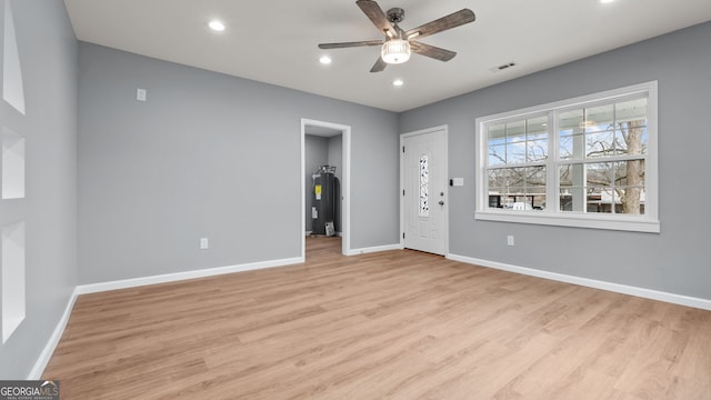 unfurnished bedroom featuring ceiling fan, electric water heater, and light wood-type flooring