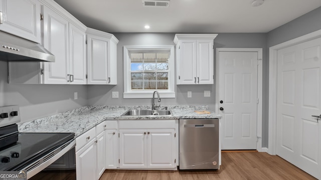 kitchen with sink, light hardwood / wood-style flooring, appliances with stainless steel finishes, light stone countertops, and white cabinets