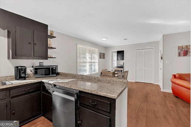 kitchen featuring stainless steel appliances, light wood-type flooring, and kitchen peninsula