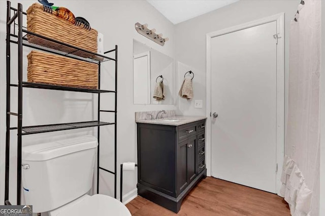 bathroom with vanity, hardwood / wood-style floors, and toilet