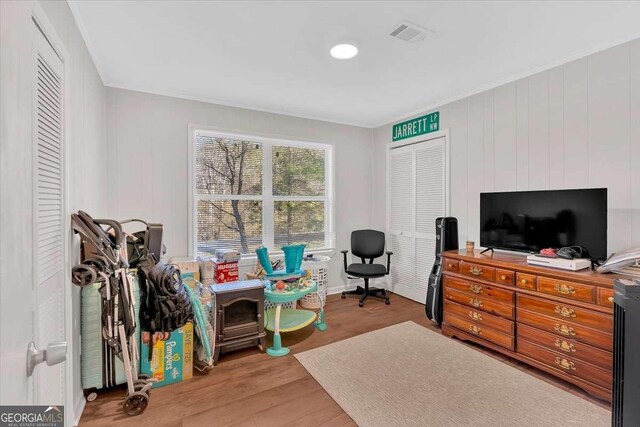 bedroom with hardwood / wood-style flooring, ornamental molding, and a closet