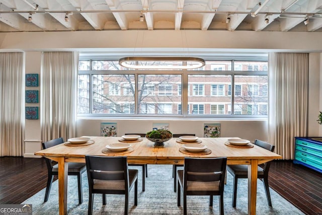 dining space featuring hardwood / wood-style flooring, a wealth of natural light, and beamed ceiling