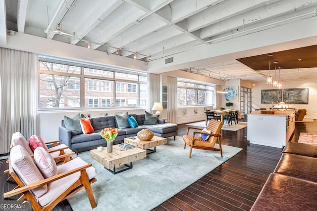 living room with dark wood-type flooring and a notable chandelier