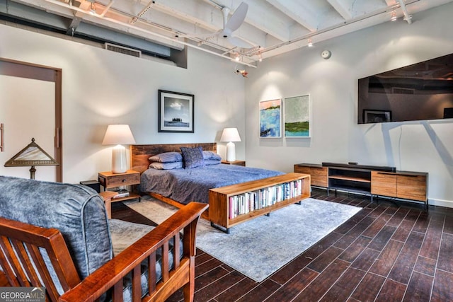 bedroom with track lighting and dark hardwood / wood-style floors