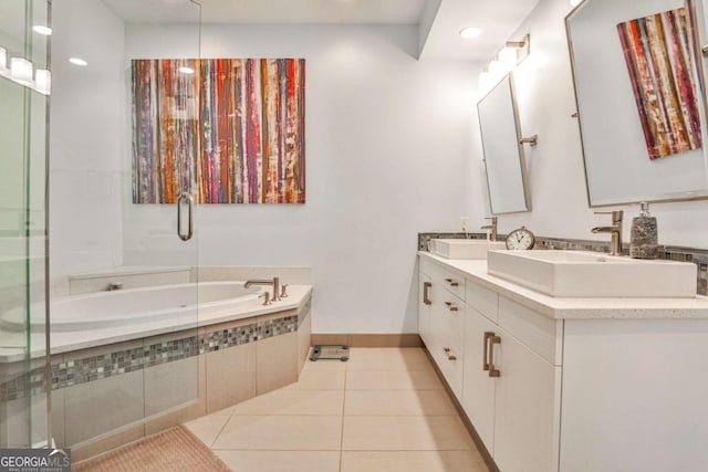 bathroom with tile patterned floors, tiled bath, and vanity