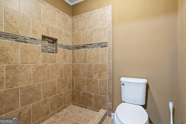 bathroom featuring tiled shower and toilet