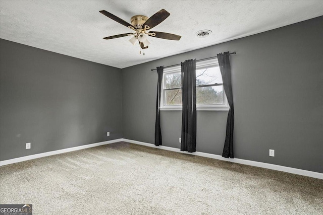 carpeted empty room with ceiling fan and a textured ceiling