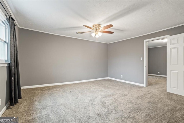 carpeted empty room featuring ceiling fan, crown molding, and a textured ceiling