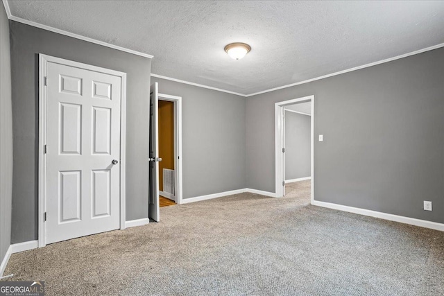 unfurnished bedroom featuring ornamental molding, light colored carpet, and a textured ceiling