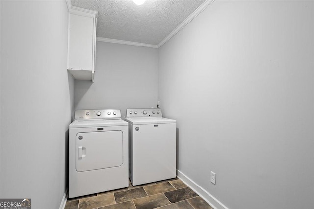 clothes washing area with cabinets, crown molding, washer and dryer, and a textured ceiling