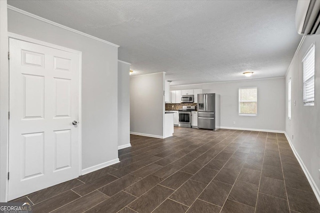 unfurnished living room with a textured ceiling, crown molding, baseboards, and a wall mounted AC