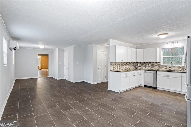 kitchen featuring sink, stainless steel appliances, a wall mounted AC, tasteful backsplash, and white cabinets