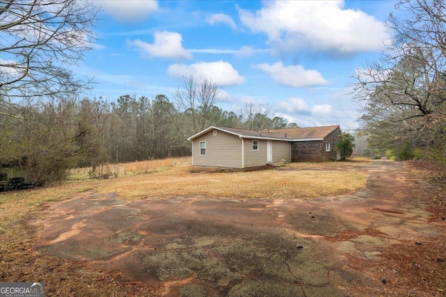 view of side of property with a yard and driveway