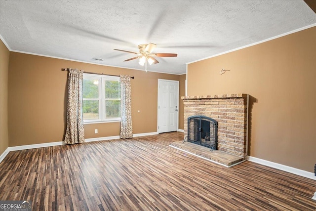 unfurnished living room with dark wood-type flooring, a fireplace, a textured ceiling, and crown molding