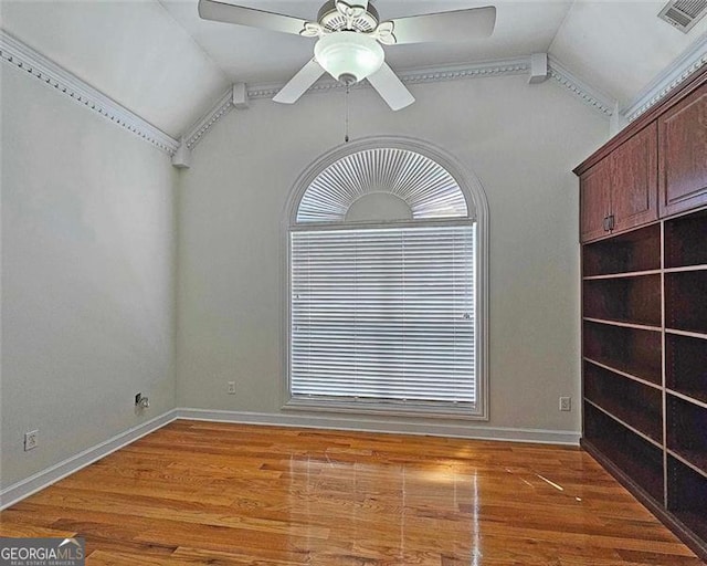 spare room with vaulted ceiling, wood-type flooring, and ceiling fan