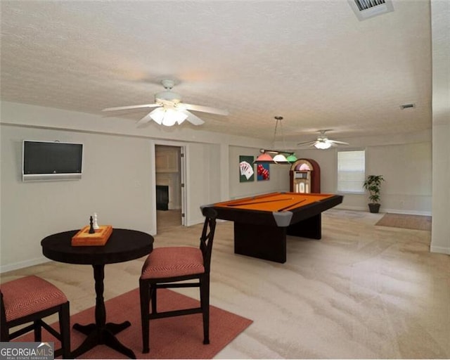 recreation room featuring light carpet, ceiling fan, pool table, and a textured ceiling