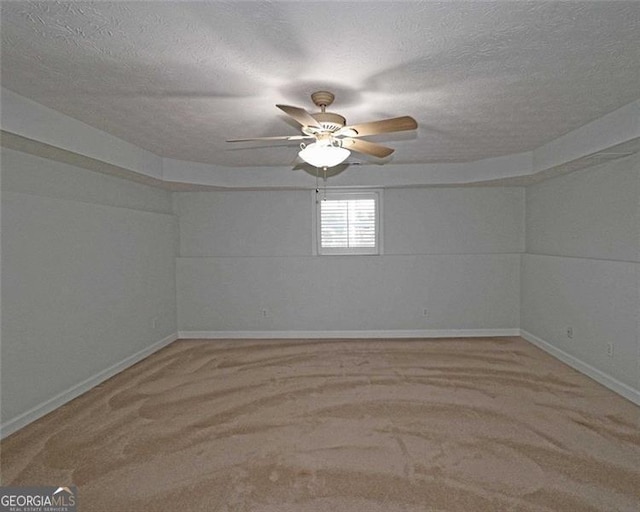 carpeted empty room featuring ceiling fan and a textured ceiling