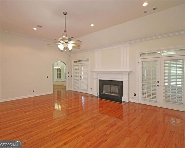 unfurnished living room featuring french doors, ceiling fan, ornamental molding, and hardwood / wood-style floors