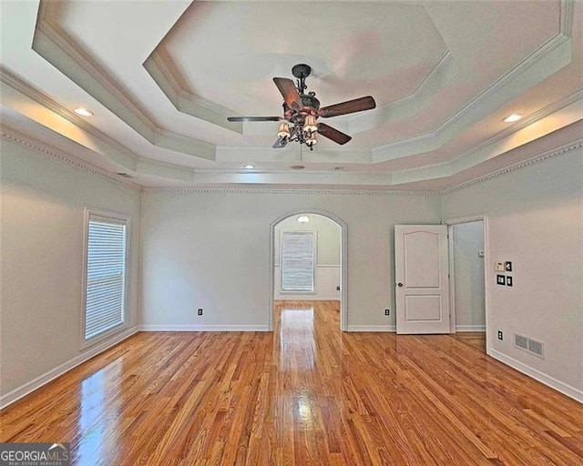 unfurnished room featuring a raised ceiling and light wood-type flooring