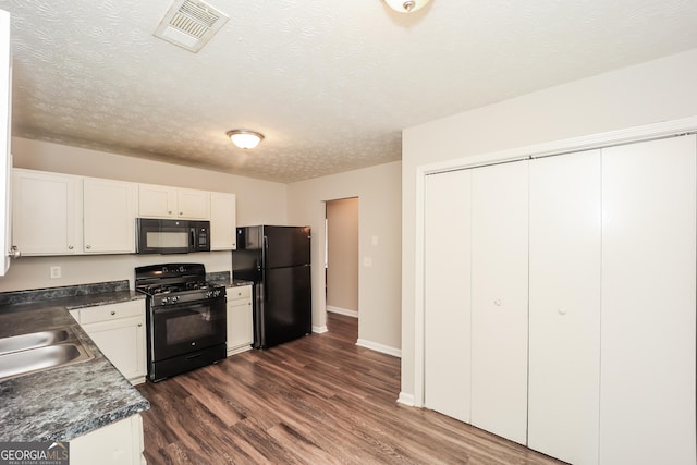 kitchen featuring sink, black appliances, a textured ceiling, dark hardwood / wood-style flooring, and white cabinets