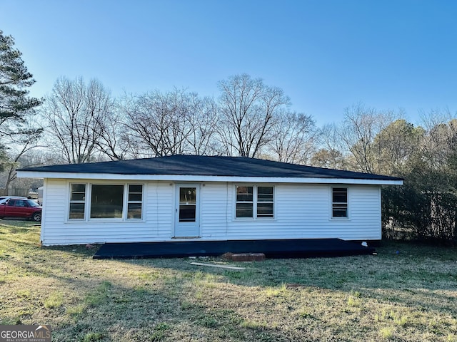 rear view of property with a yard