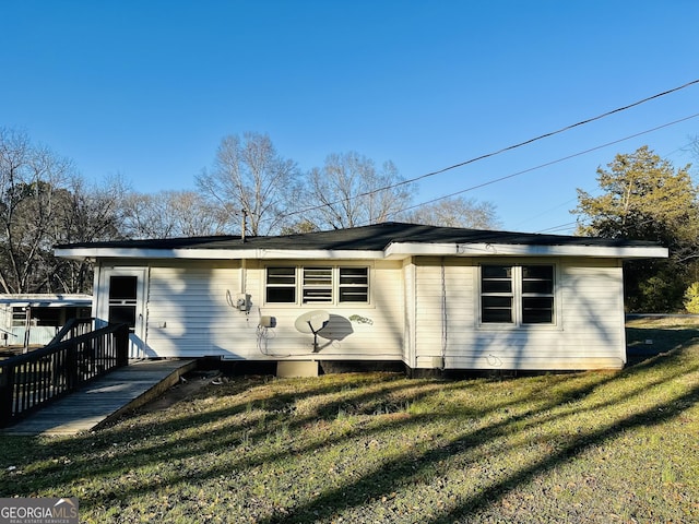 back of house with a wooden deck and a lawn