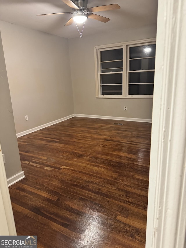 unfurnished room with ceiling fan and dark hardwood / wood-style floors