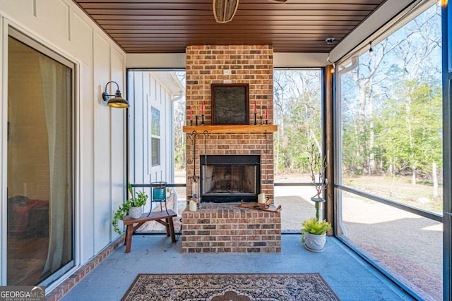 unfurnished sunroom with an outdoor brick fireplace, wood ceiling, and a wealth of natural light