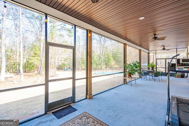 unfurnished sunroom with ceiling fan